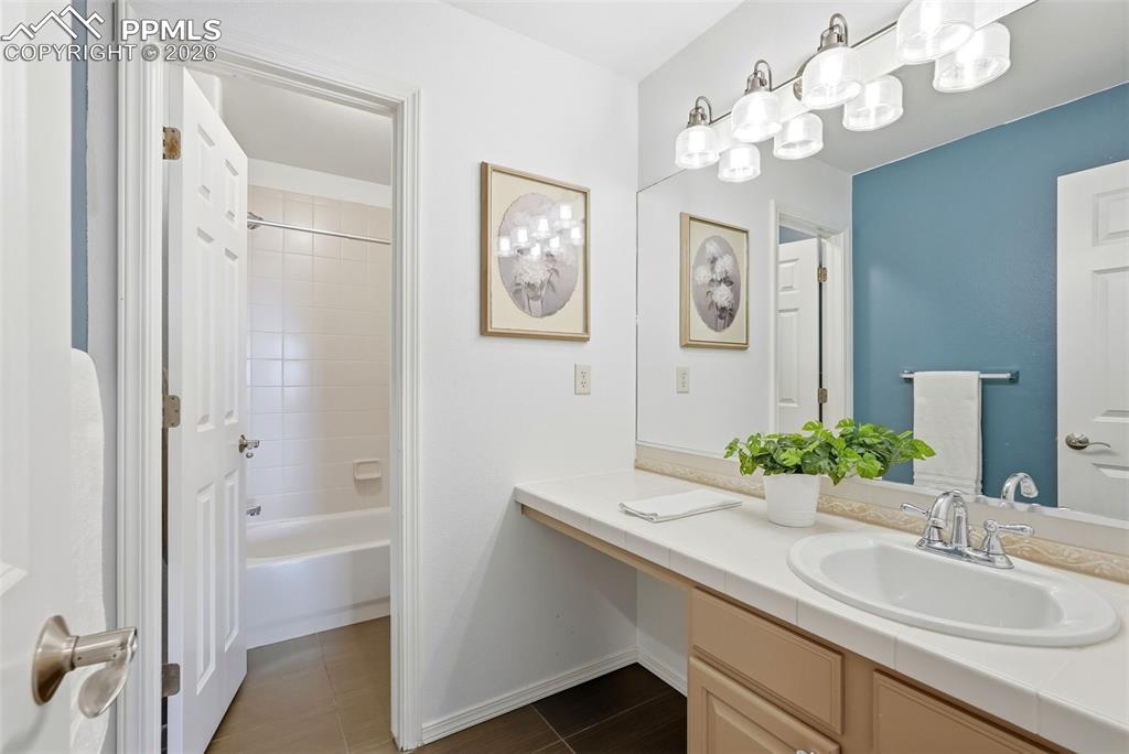 10744 Rhinestone Drive Colorado Springs, CO 80908 - Photo 31 of 50 a bathroom with a sink a large mirror and a window