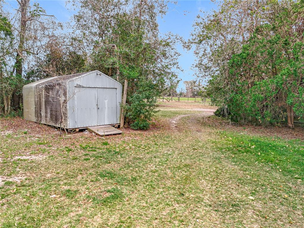 41204 Emeralda Island Road Leesburg, FL 34788 - Photo 31 of 53 a view of a barn in the middle of a yard