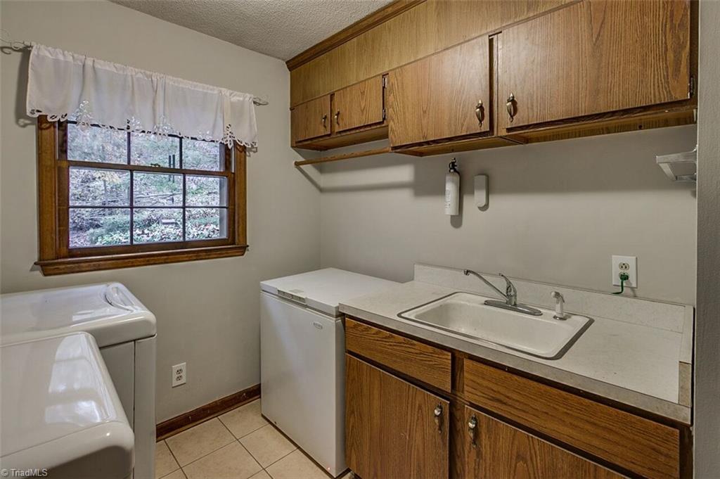 5902 Dehaven Road Pleasant Garden, NC 27313 - Photo 11 of 27 Laundry room offers a sink and plenty of storage.