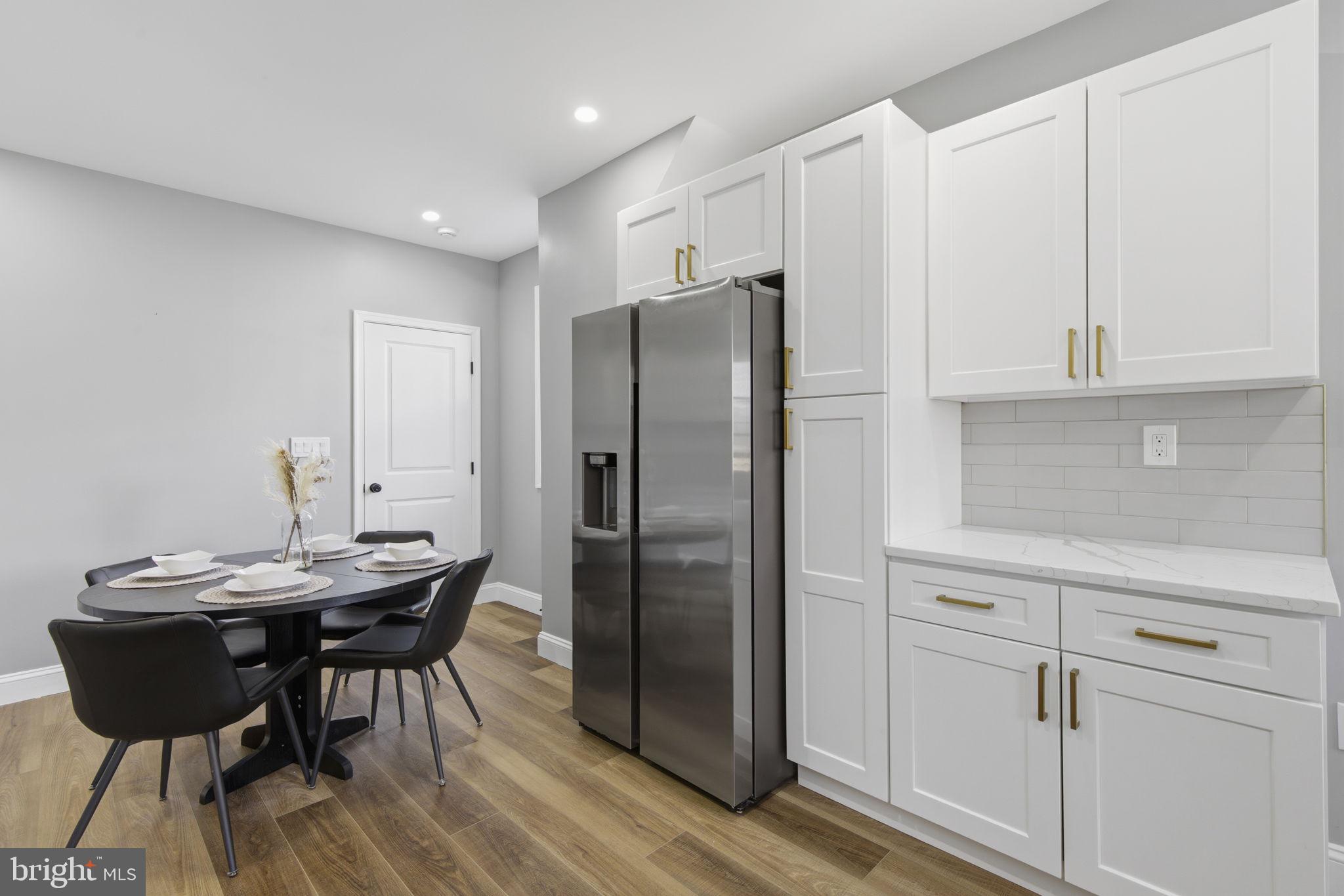1600 Federal Street Baltimore, MD 21213 - Photo 8 of 31 a kitchen with stainless steel appliances granite countertop a table chairs and a refrigerator