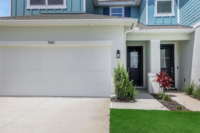a view of a house with a yard and a potted plant