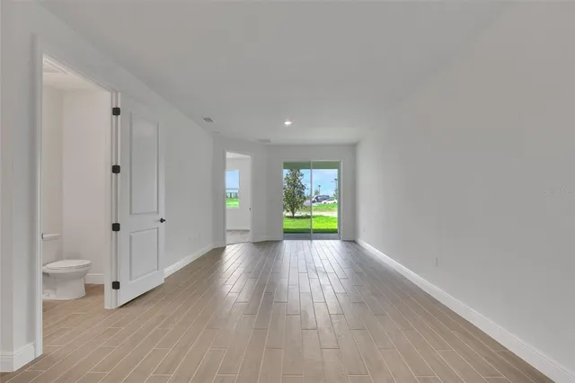 a view of a room with wooden floor and a toilet