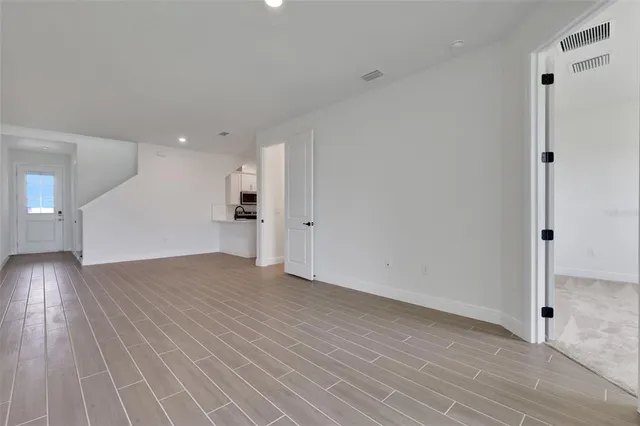 a view of a big room with wooden floor and windows