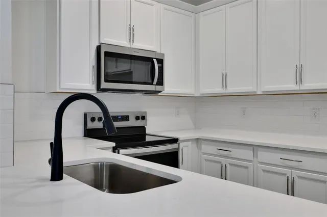 a kitchen with white cabinets and a sink