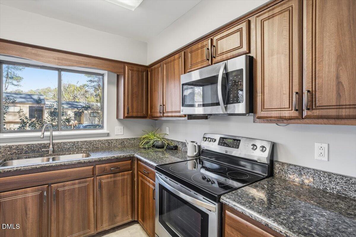 5021 Tall Pines Court Raleigh, NC 27609 - Photo 11 of 30 a kitchen with stainless steel appliances granite countertop a stove a sink and a microwave