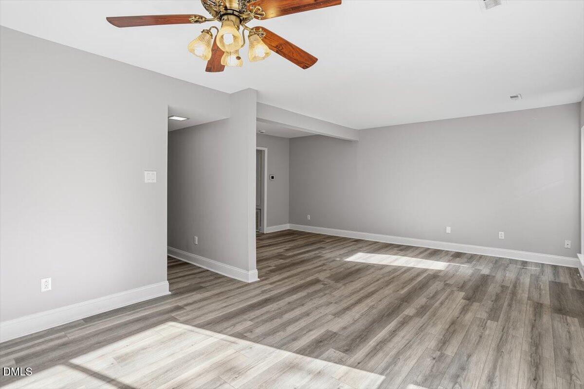 5021 Tall Pines Court Raleigh, NC 27609 - Photo 16 of 30 an empty room with wooden floor fan and windows