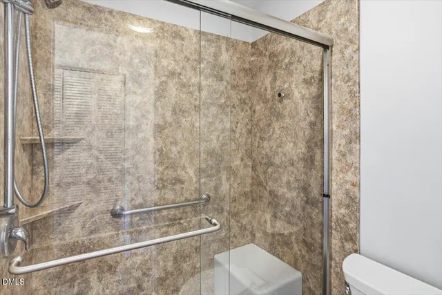 a bathroom with a shower and toilet