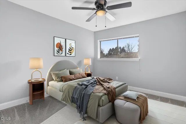 a bed room with a bed and a painting on the wall