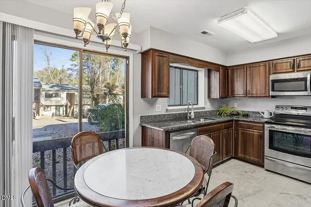 a kitchen with sink a stove and chairs