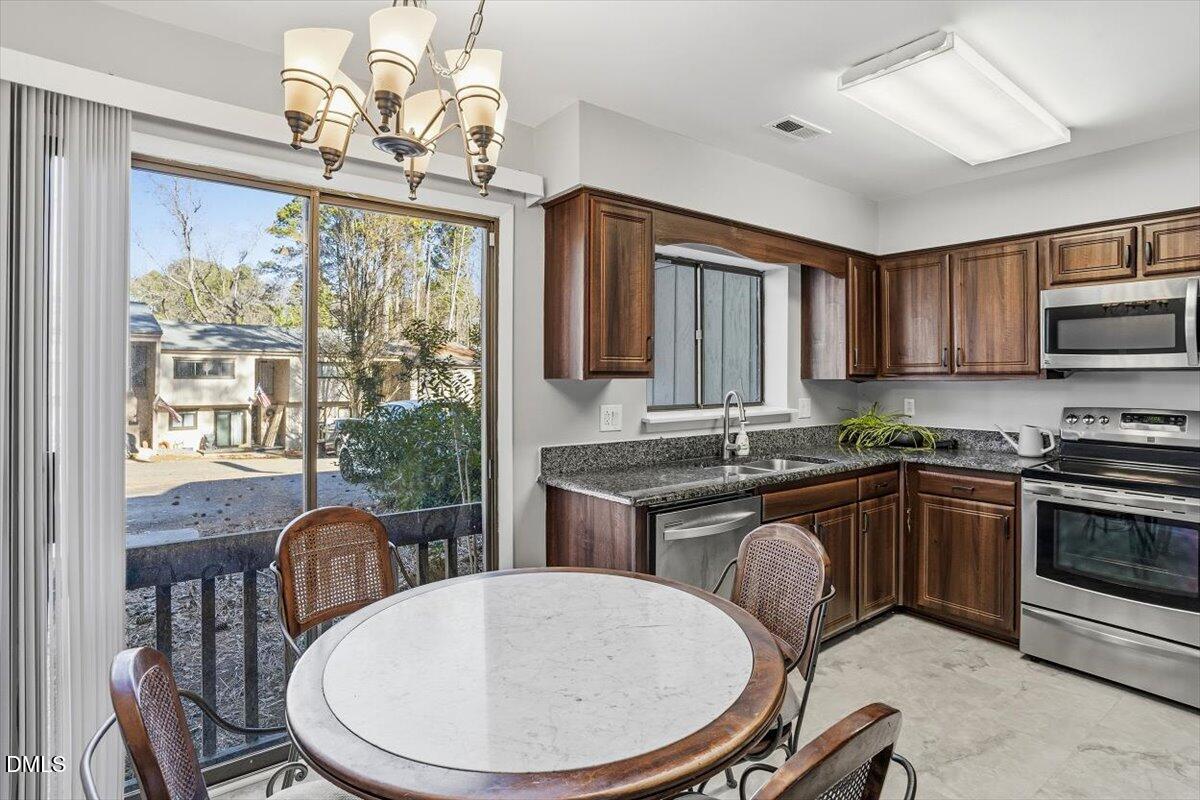5021 Tall Pines Court Raleigh, NC 27609 - Photo 6 of 30 a kitchen with sink a stove and chairs