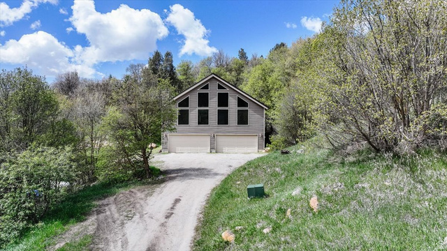7203 East Cub River Road Preston, ID 83263 - Photo 26 of 33 View of front of home featuring driveway, a garage, and view of wooded area