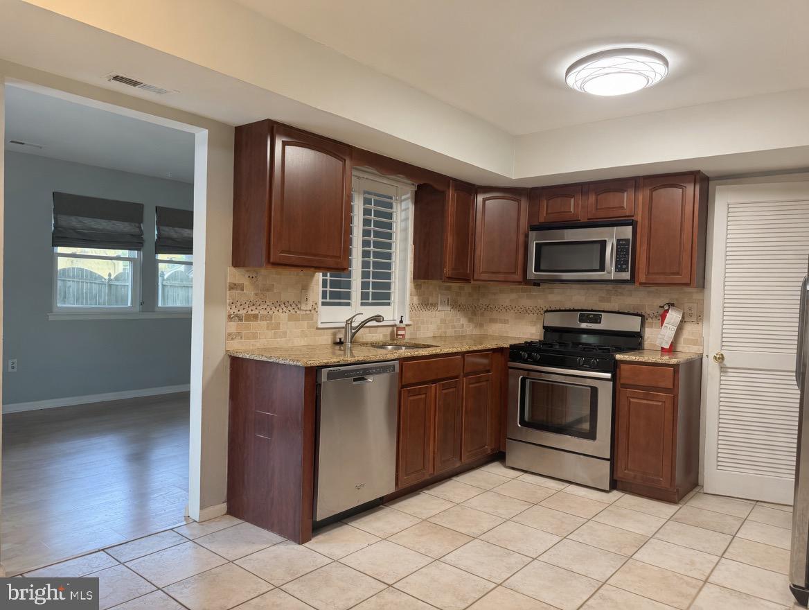 2 Goshawk Court Voorhees, NJ 08043 - Photo 10 of 33 a kitchen with granite countertop a stove top oven sink and cabinets