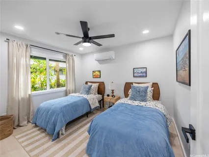 a bedroom with two beds and a large window
