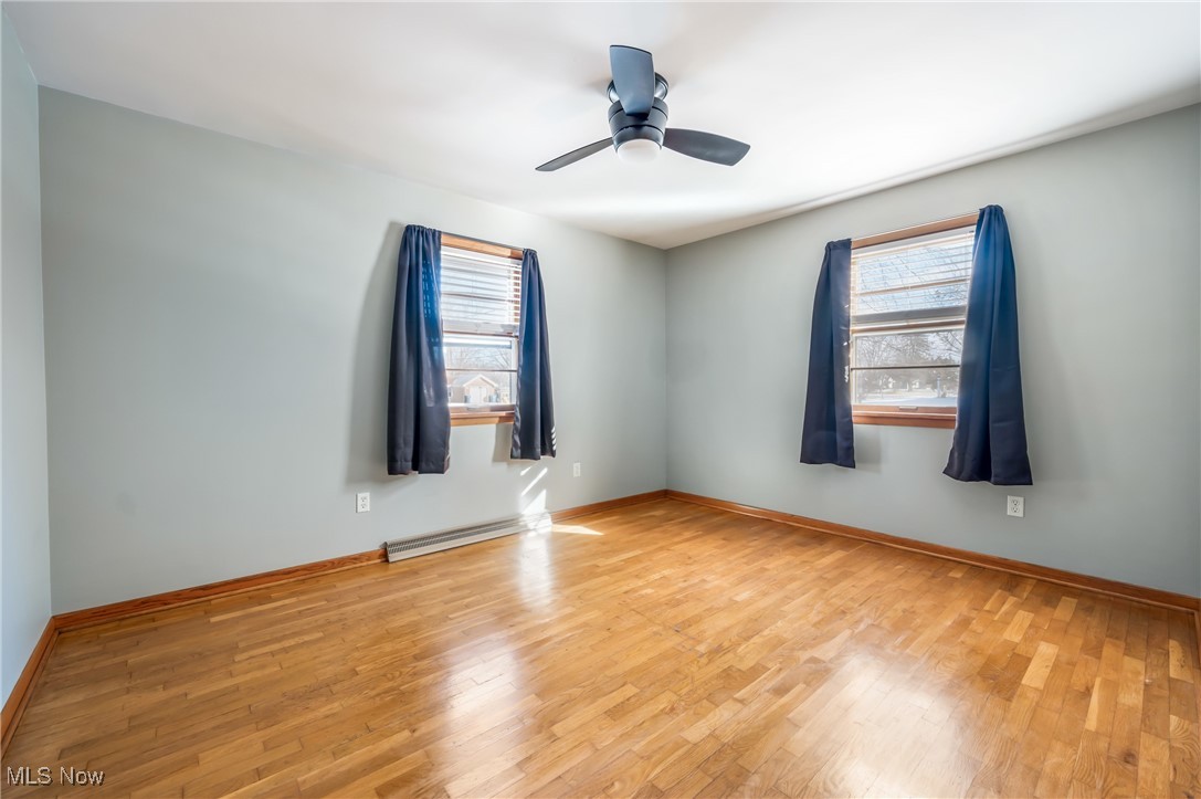 3210 Oser Road Norton, OH 44203 - Photo 32 of 47 Empty room with ceiling fan, a healthy amount of sunlight, and light wood-type flooring
