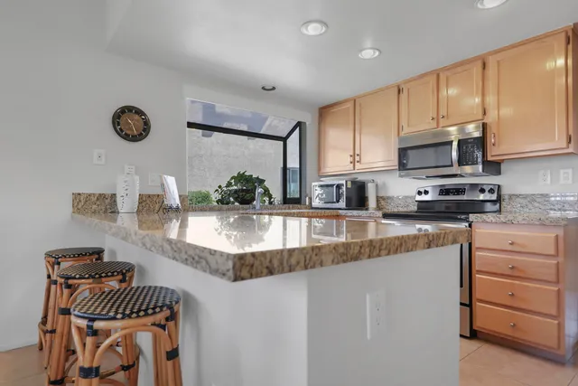 a kitchen with stainless steel appliances granite countertop a sink a stove counter space and cabinets