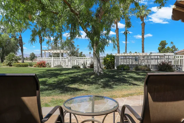 a view of a chairs and table in backyard