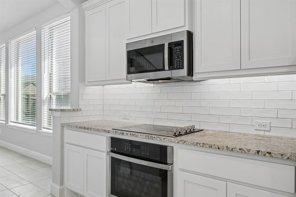 117 Joshua Tree Court Forney, TX 75126 - Photo 11 of 29 a kitchen with stainless steel appliances granite countertop white cabinets and a stove top oven