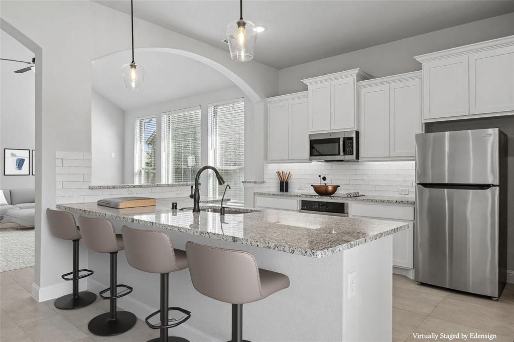 117 Joshua Tree Court Forney, TX 75126 - Photo 8 of 29 a kitchen with stainless steel appliances granite countertop a sink a stove a refrigerator a center island and furniture