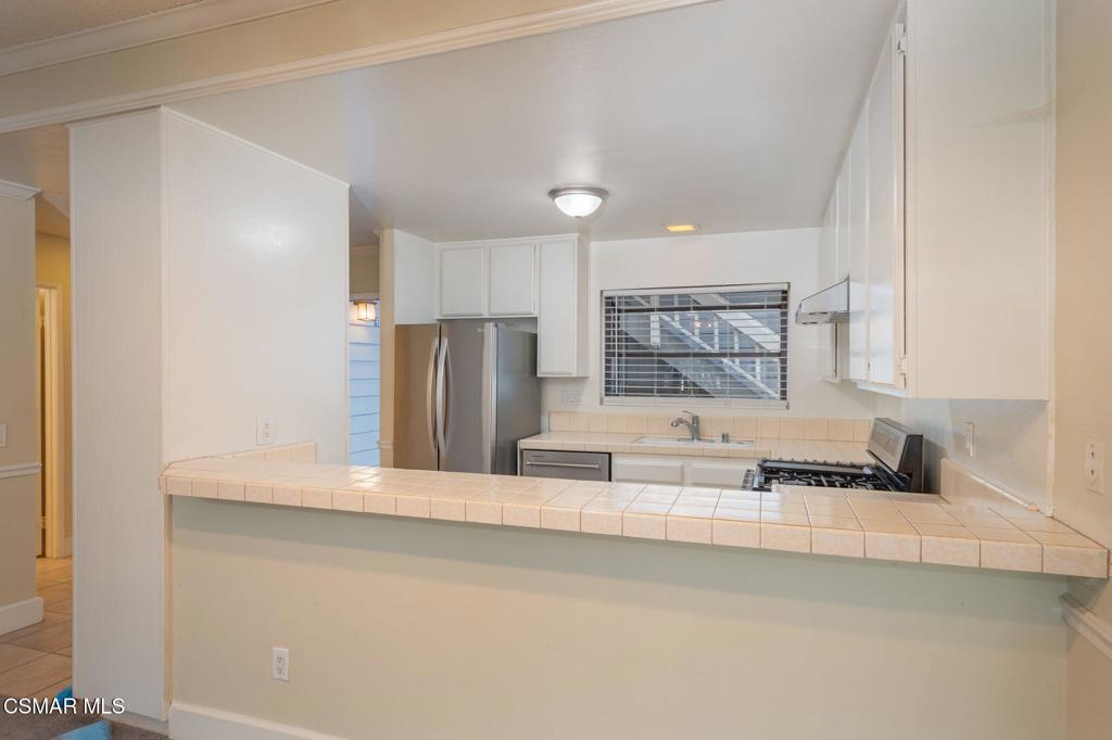 647 Arneill Road Camarillo, CA 93010 - Photo 8 of 27 a kitchen with stainless steel appliances granite countertop a sink and a refrigerator