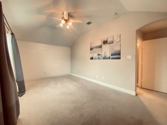 en empty room with windows and ceiling fan