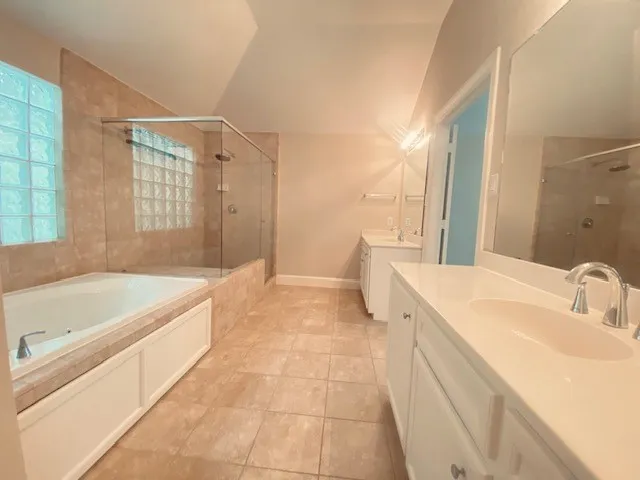a spacious bathroom with a tub sink and mirror