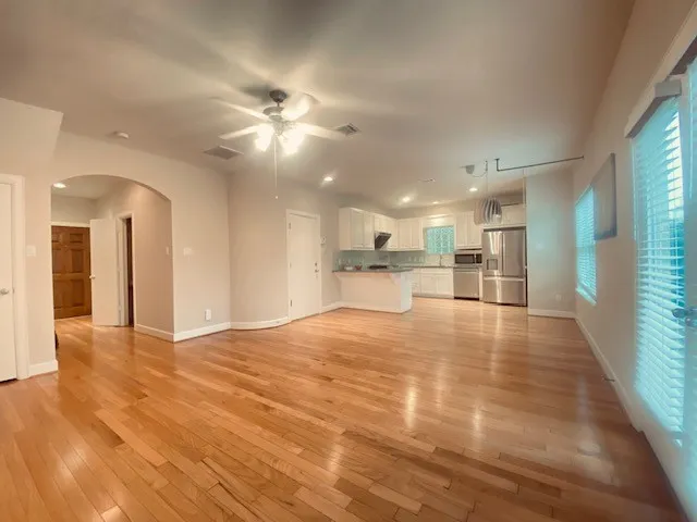 a view of an empty room and kitchen view