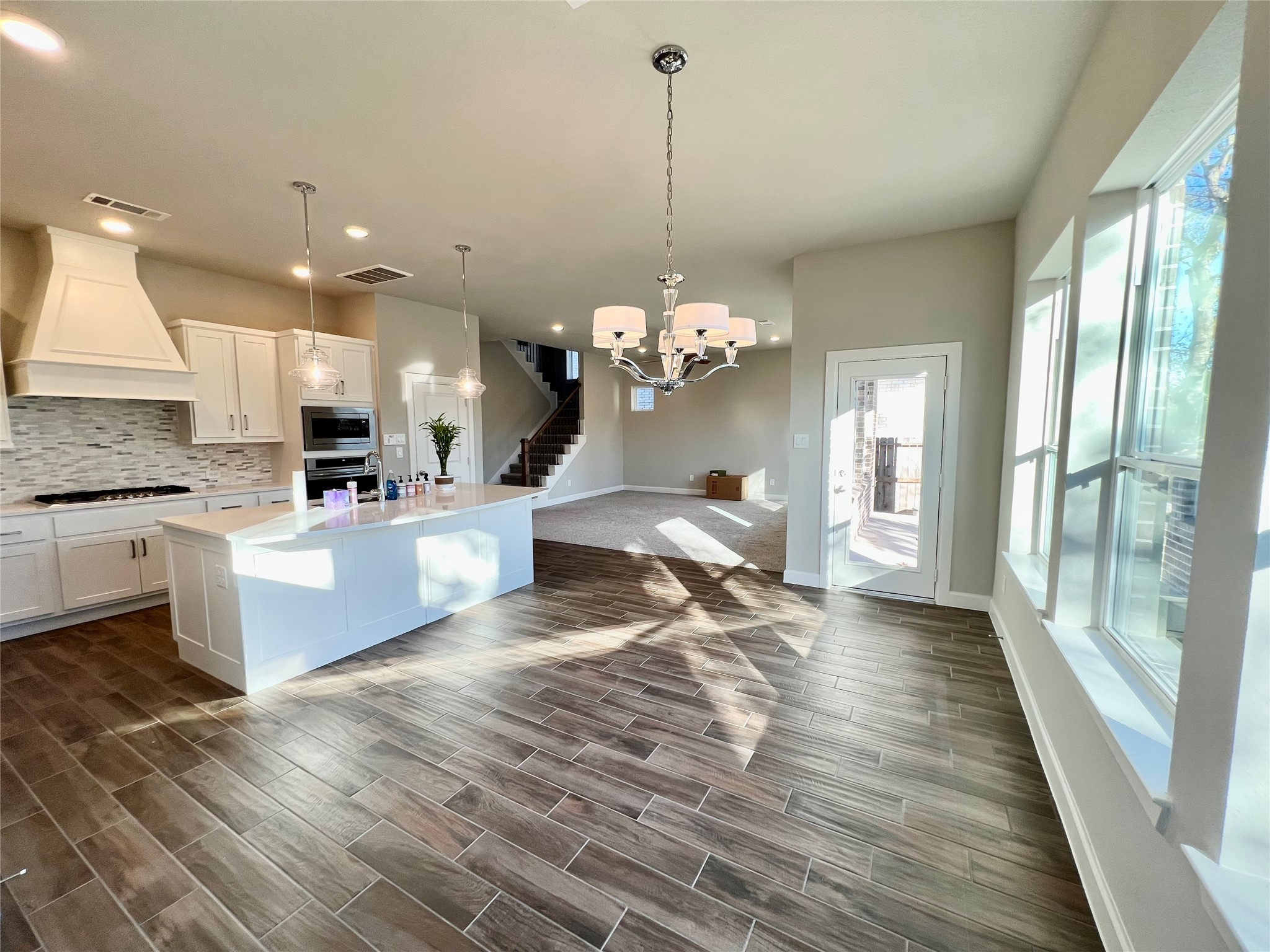 547 Kingston Lane Conroe, TX 77384 - Photo 11 of 50 a large kitchen with granite countertop a stove a sink dishwasher and a fireplace with wooden floor
