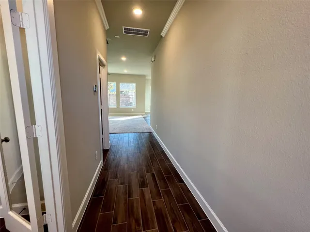 a view of a hallway with wooden floor and staircase