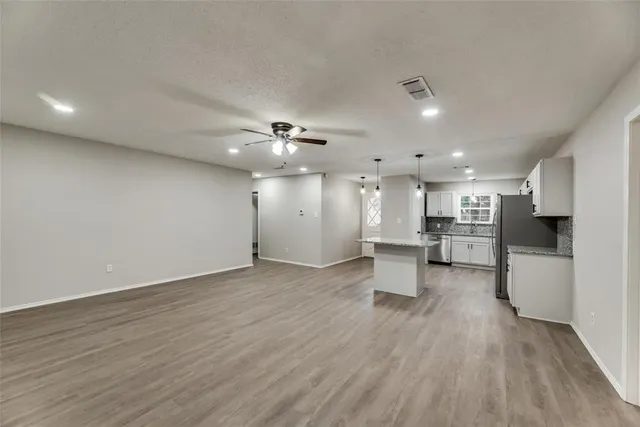 a view of a kitchen with cabinets and wooden floor