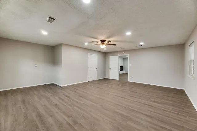 a view of an empty room with wooden floor