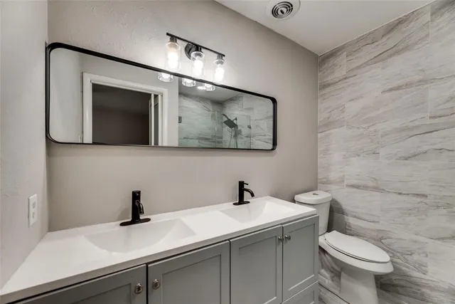 a bathroom with a sink a toilet and mirror