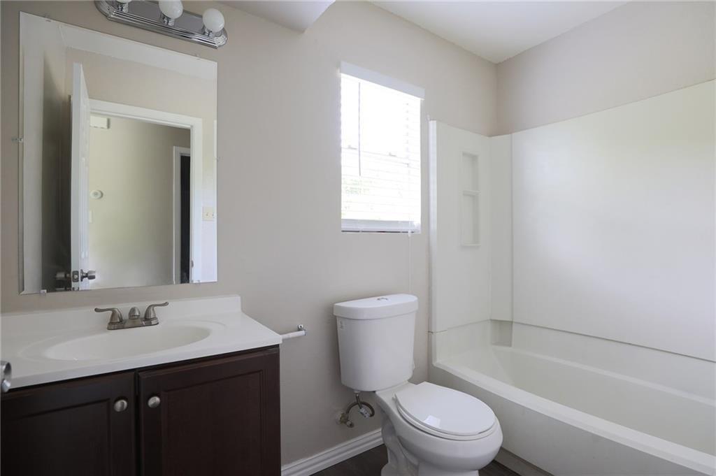 1410 Ransom Street Pflugerville, TX 78660 - Photo 20 of 22 a bathroom with a sink a toilet a mirror and shower