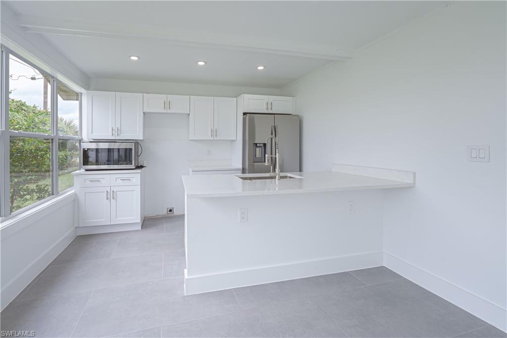 7233 Coolidge Road Fort Myers, FL 33967 - Photo 12 of 36 a kitchen with white cabinets and window
