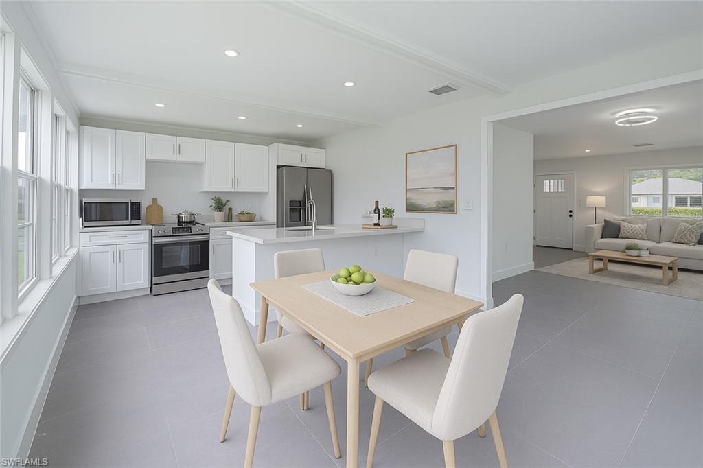 7233 Coolidge Road Fort Myers, FL 33967 - Photo 14 of 36 a kitchen with kitchen island white cabinets and stainless steel appliances
