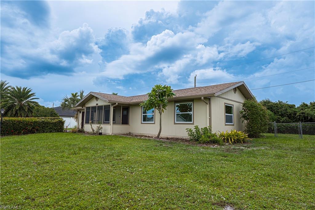 7233 Coolidge Road Fort Myers, FL 33967 - Photo 3 of 36 a front view of house with yard and trees in the background
