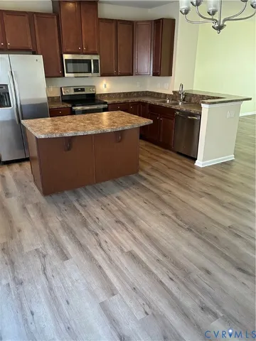a large kitchen with granite countertop a sink and a stove top oven