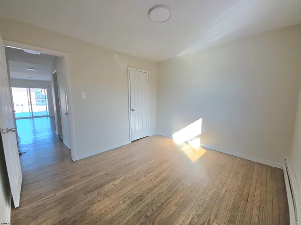 a view of an empty room and wooden floor