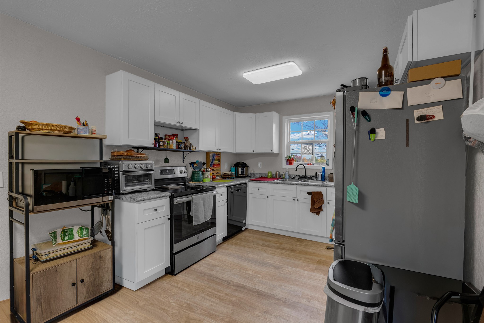 921 Barney Holt Road Jamestown, TN 38556 - Photo 2 of 24 a kitchen with granite countertop a refrigerator stove and microwave
