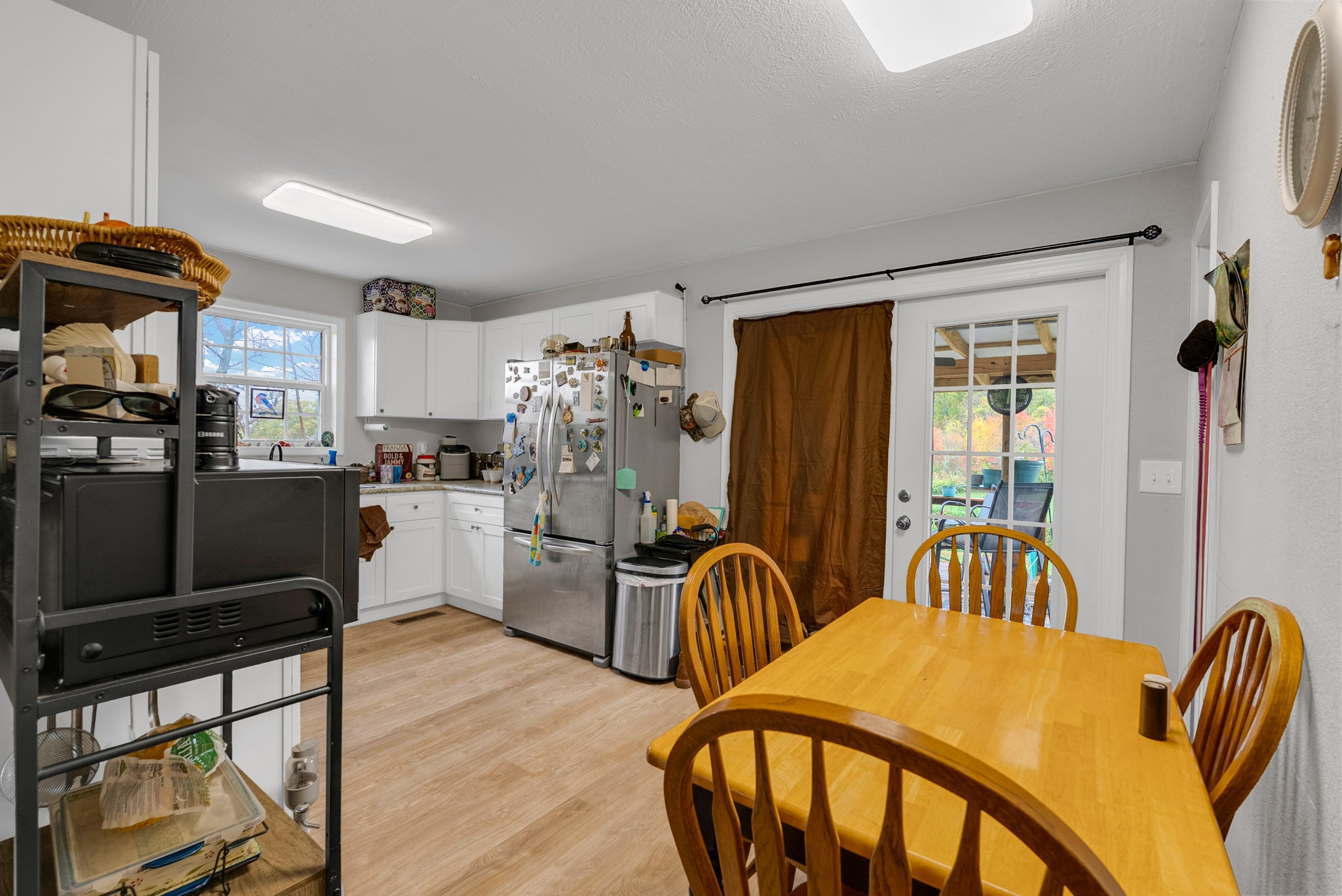 921 Barney Holt Road Jamestown, TN 38556 - Photo 5 of 24 a kitchen with a refrigerator a sink dishwasher a dining table and chairs with wooden floor