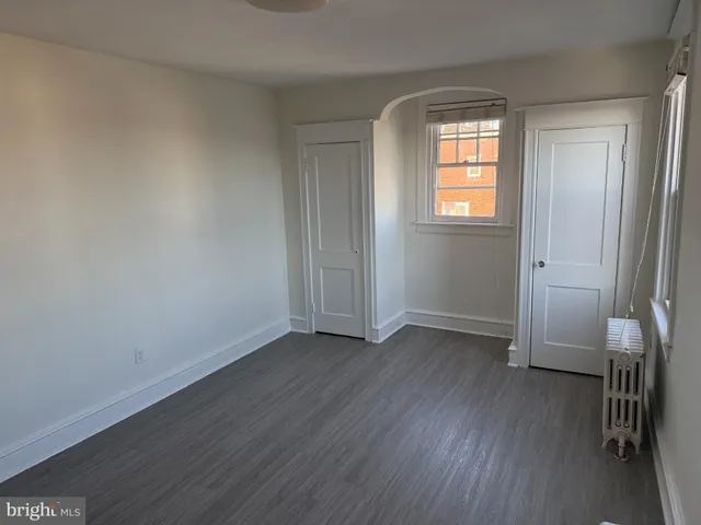 an empty room with wooden floor and a window
