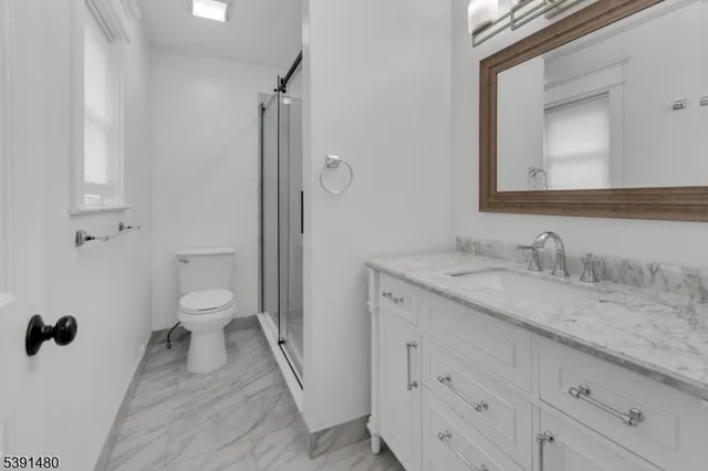 a bathroom with a granite countertop sink toilet and shower