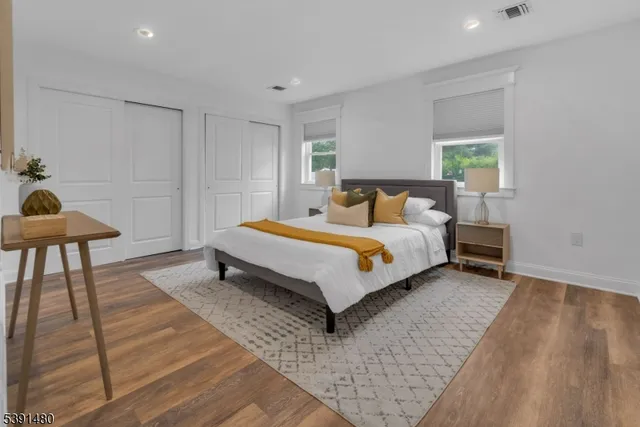 a bed sitting in a spacious bedroom next to a window