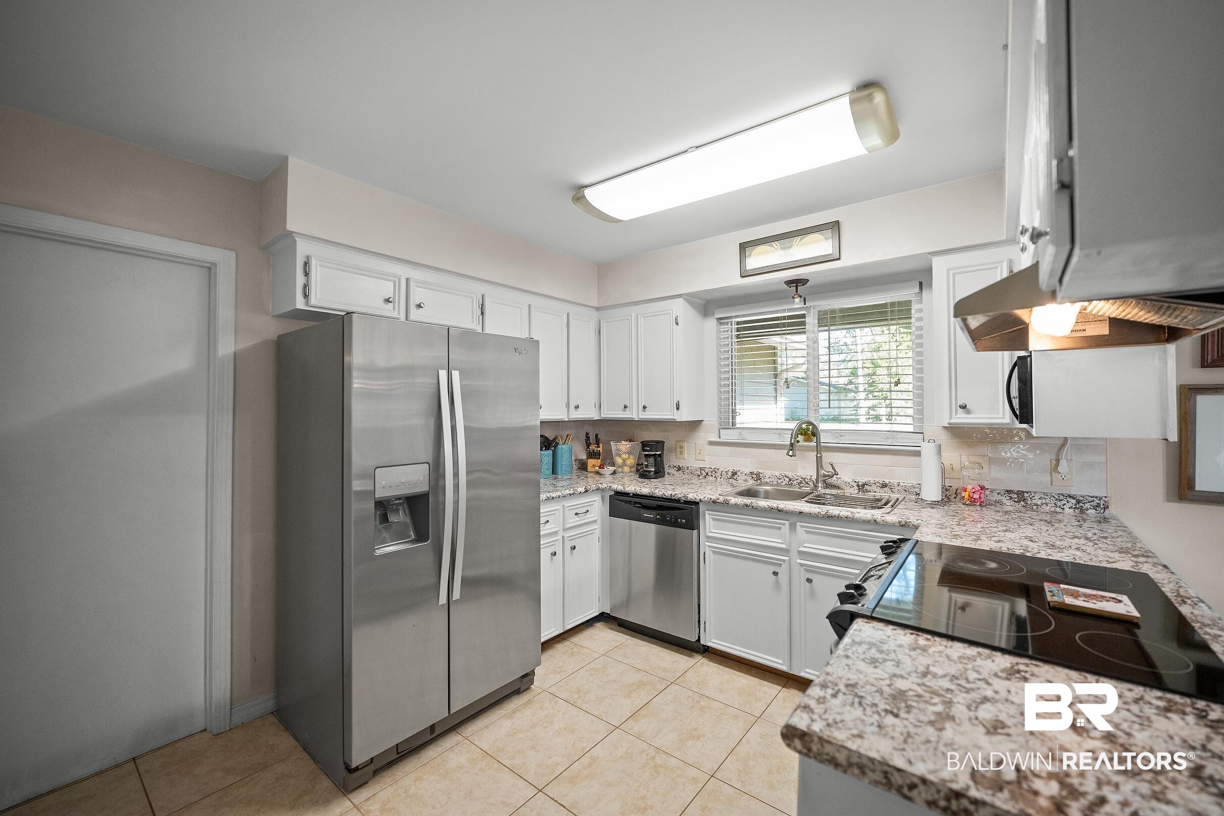 120 Dunbar Loop Daphne, AL 36526 - Photo 10 of 25 Kitchen featuring stainless steel appliances, white cabinets, light tile patterned floors, and ventilation hood