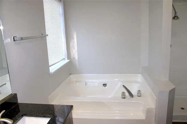 a view of a hallway with wooden floor and a window