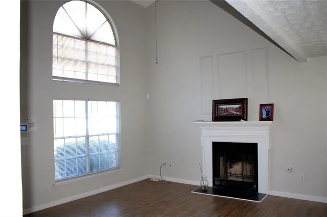 an empty room with a fireplace and windows
