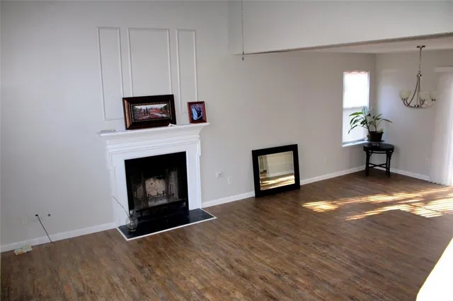 a view of an empty room with a fireplace and a window