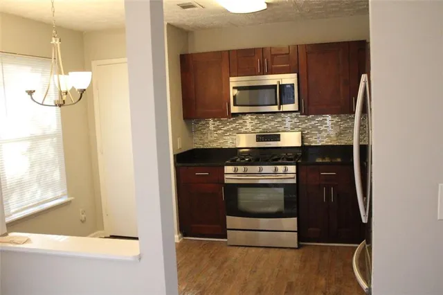 a kitchen with stainless steel appliances wooden cabinets and a stove