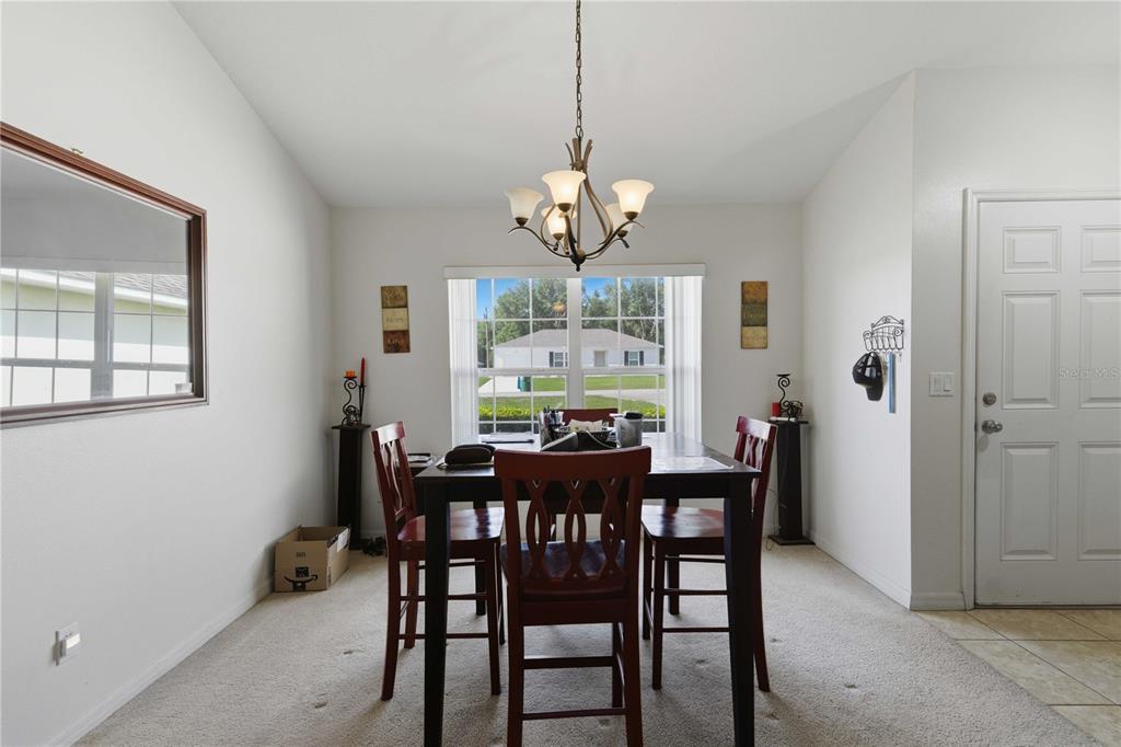 3959 Southwest 129th Street Ocala, FL 34473 - Photo 6 of 27 a view of a dining room with furniture a chandelier and wooden floor