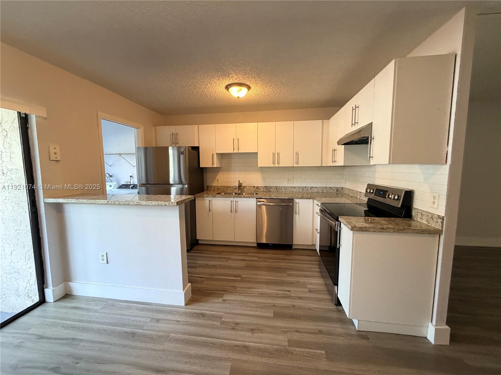 10350 Southwest 220th Street, Unit 143 Cutler Bay, FL 33190 - Photo 11 of 18 a kitchen with white cabinets and white appliances