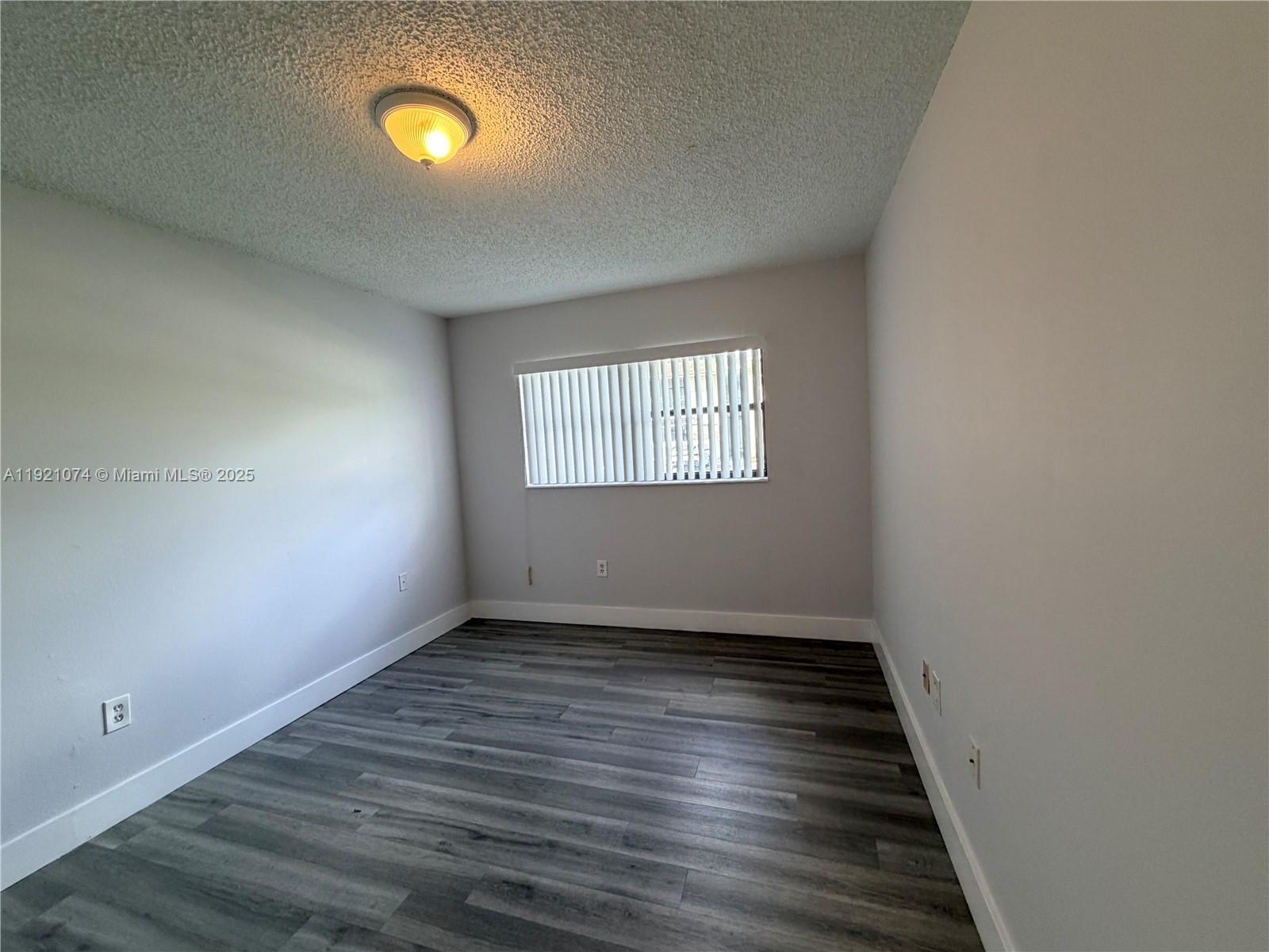 10350 Southwest 220th Street, Unit 143 Cutler Bay, FL 33190 - Photo 14 of 18 wooden floor in an empty room with a window